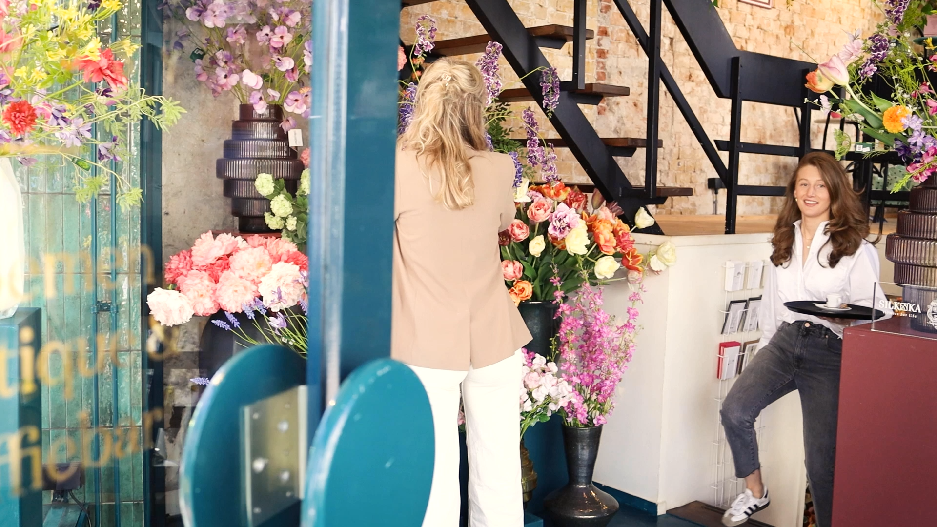 Interieur van bloemenwinkel met kleurrijke boeketten en twee vrouwen