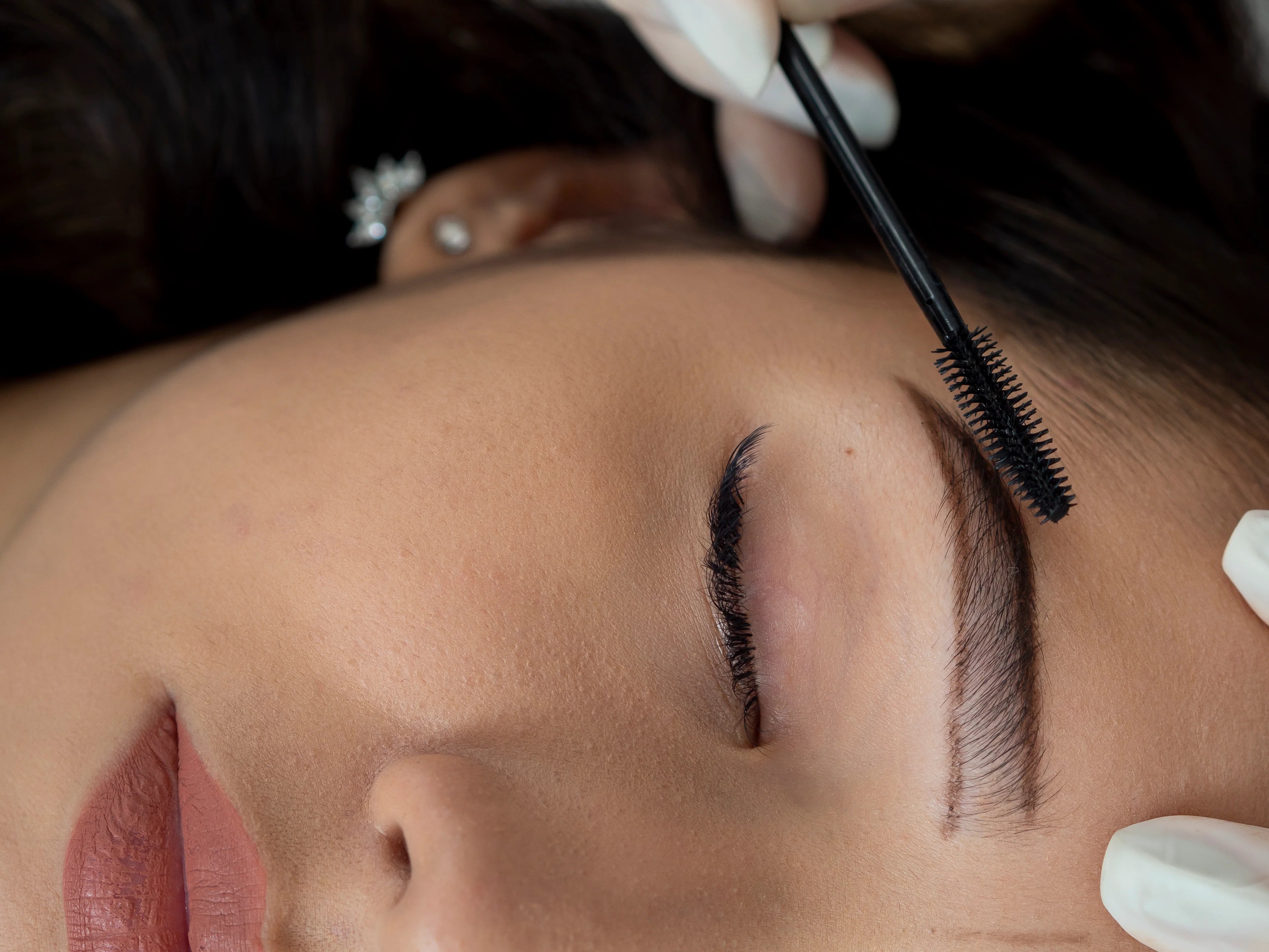 Klant ondergaat microblading behandeling van wenkbrauwen