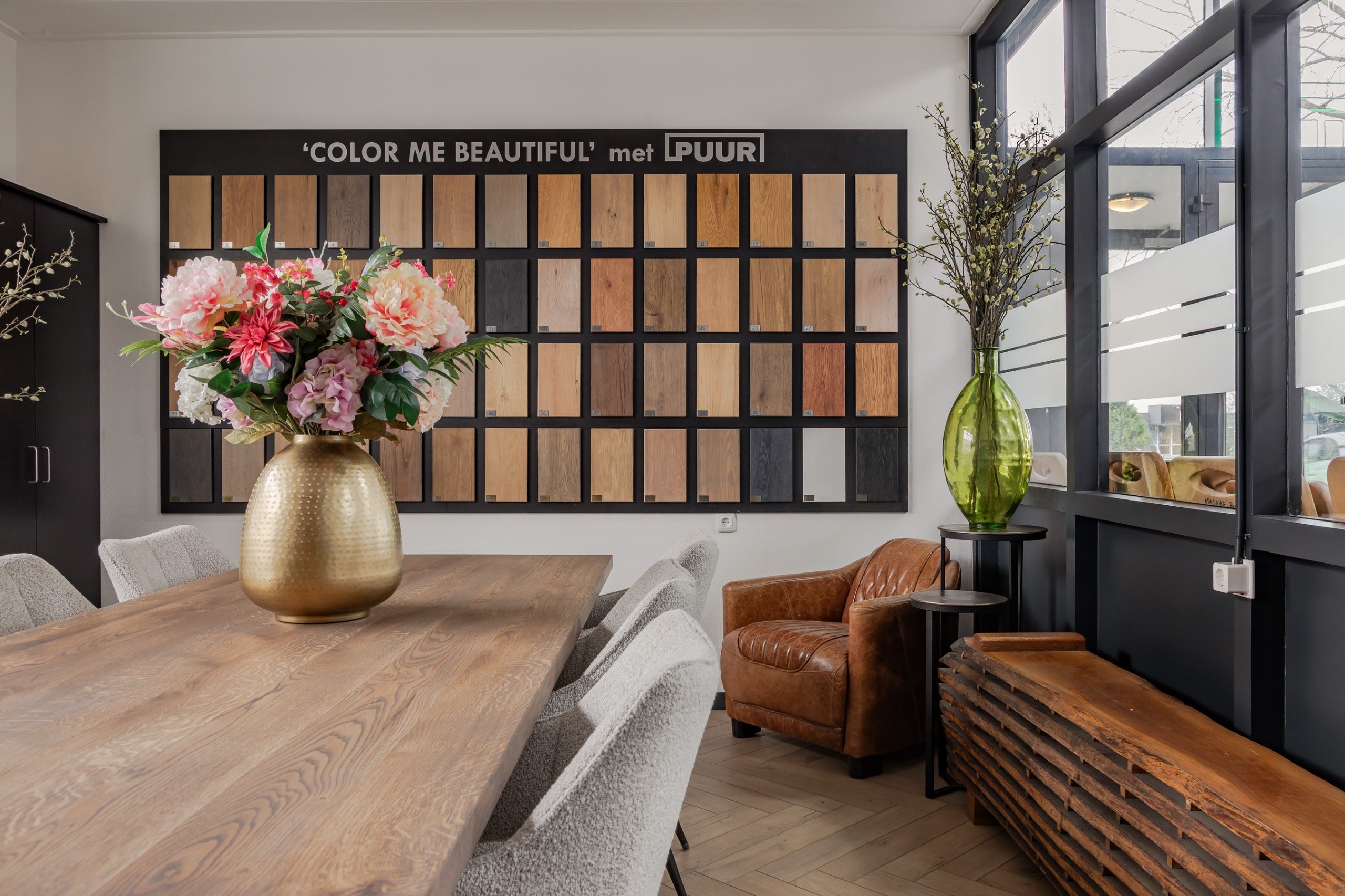 Showroom van PUUR met wand vol houtstalen en interieursetting
