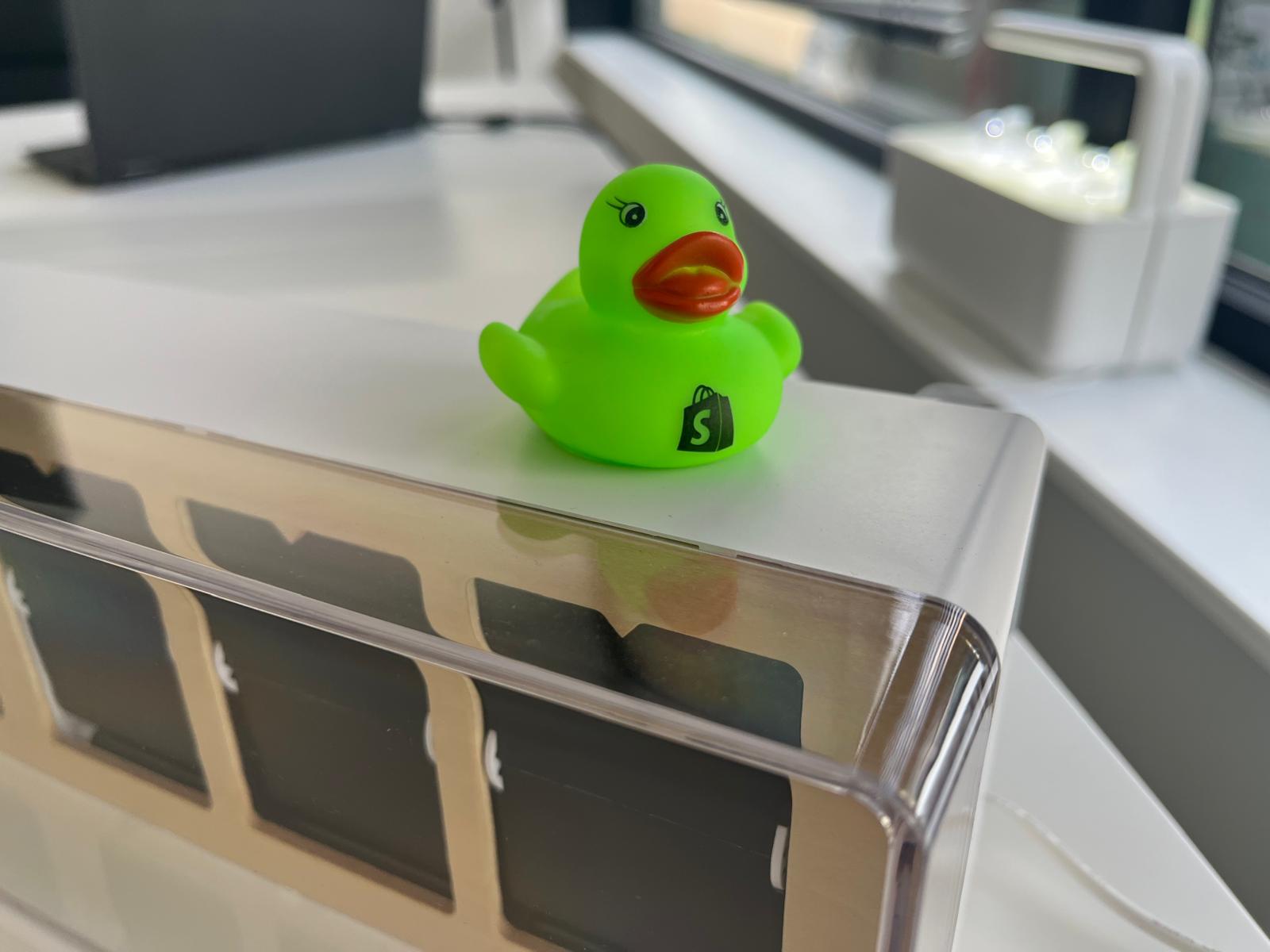 Groene Shopify eend op bureau in het kantoor van KlikSlim
